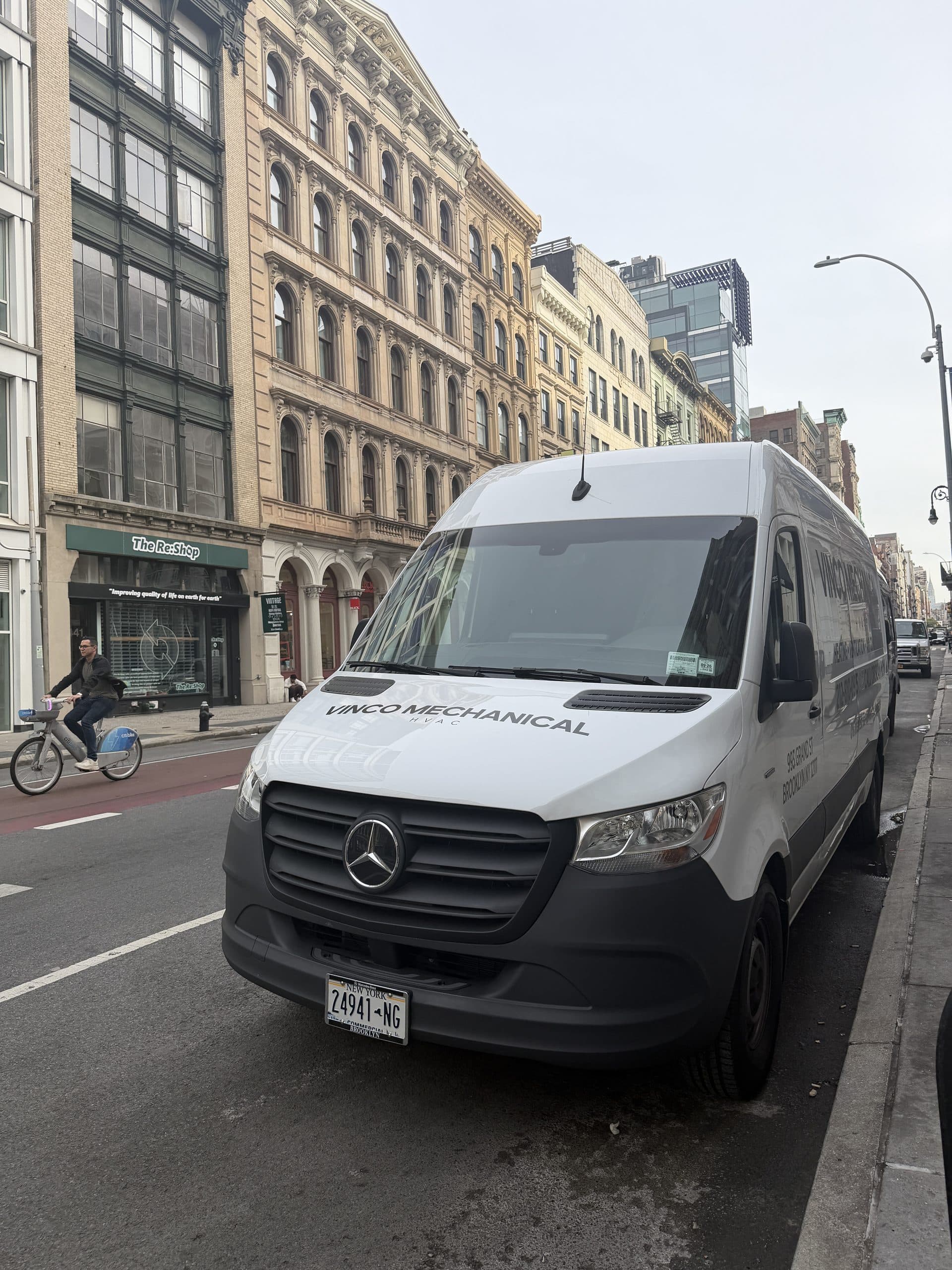 White Mercedes eSprinter electric van in Vinco Mechanical livery parked on Broadway in SoHo below a cast-iron loft building