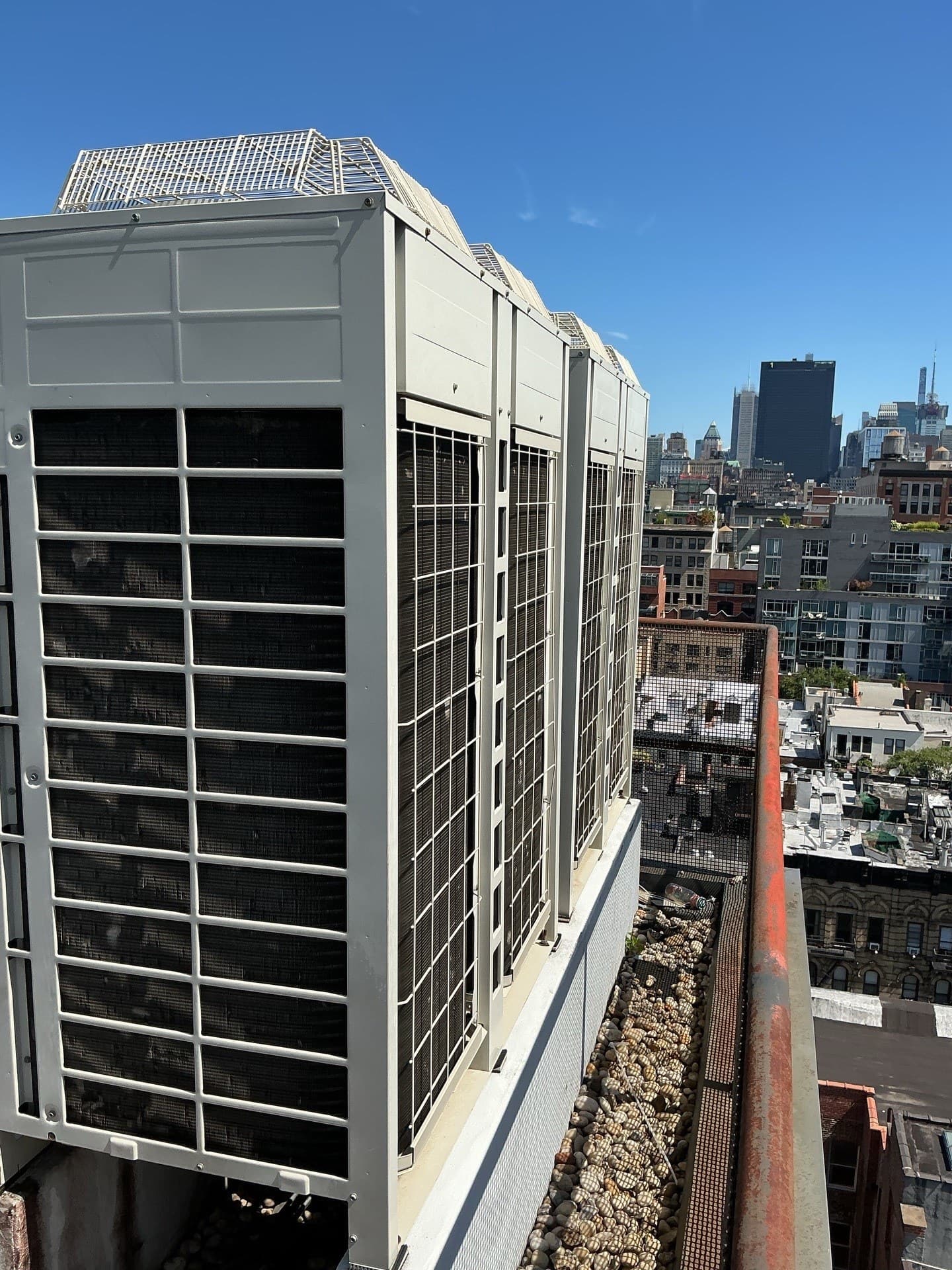 Bank of Daikin VRV condensers on a Manhattan high-rise parapet with the Midtown skyline behind